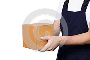 Man in dark blue overalls giving cardboard box, isolated on white background