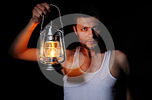 Man in the dark with a kerosene lamp