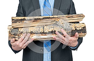 Man in a dark suit and tie holds firewood in his hands, without a face, isolated on a white background