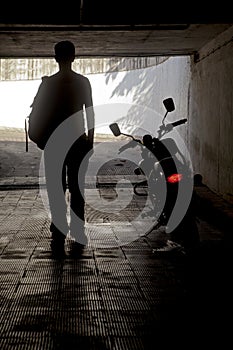 Man in dark tunnel near motorbike