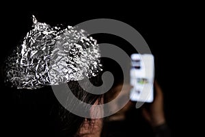 Man in the dark wearing a tin foil hat photo