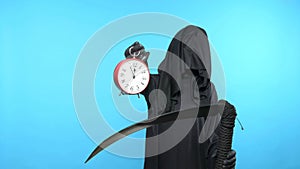 A man in a death suit with a scythe, shows a clock. blue background