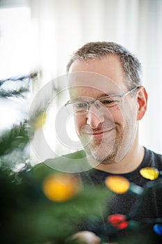 Man decorating a Christmas Tree