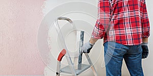 Man decorator plastering wall using a construction trowel.