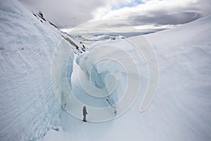 Man in the deep glacier crevasse - Arctic photo