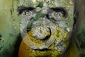 Man with deep and hypnotic gaze, the skin covered with green plants