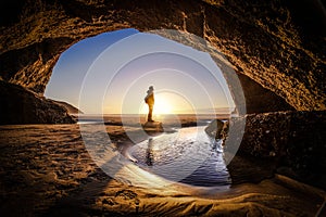 Man deep thinking inside wharariki beach cave in New Zealand