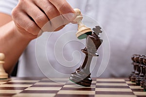 Man Defeating King Chess Piece With Pawn