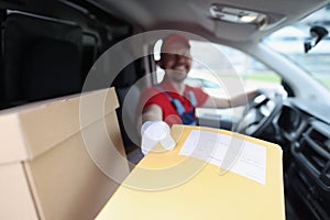 Man delivering yellow envelope from car closeup