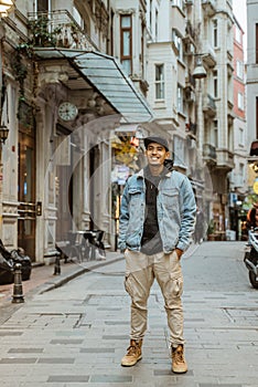 man with denim jacket smiling to camera full body portrait