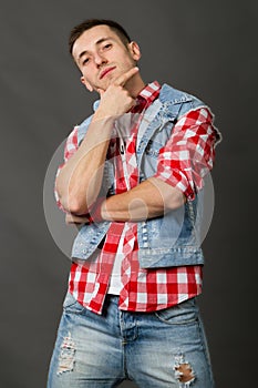 Man in a denim vest on a gray background