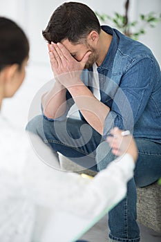 man with depression crying during psychotherapy session