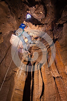 Man descending into cave photo