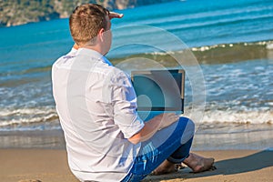 Man on a desert island with a laptop