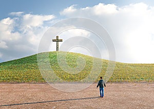 Man in the desert seeking salvation by faith in Jesus Christ looking at the cross. Biblical concept of Christianity