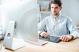 Man designer working using computer and graphic tablet at workplace