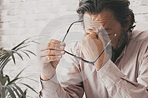 Man at the desk receiving bad news on the phone and touching his front with desperation. Business problems people in the office.