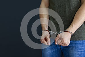Man detained in handcuffs indoors. Criminal law