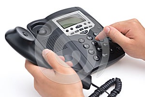 Man dialing a black telephone on white background