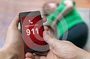 Man dialing emergency (911 number) on smartphone. Injured woman.