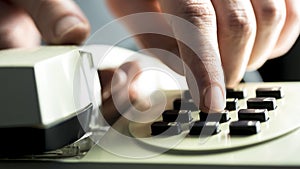 Man dialing on a landline telephone