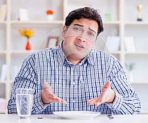 Man on diet waiting for food in restaurant