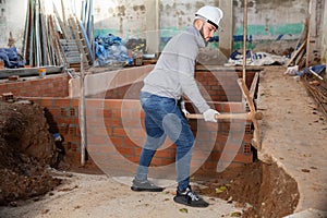 Man digging ground with pickaxe