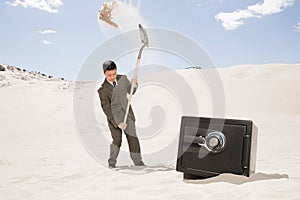 Man digging by safe in desert