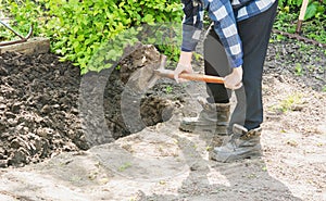Man digging with a shovel a garden bed