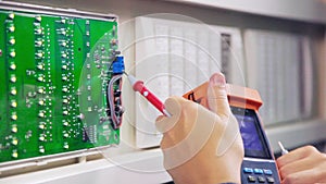 Man with digital meter checks circuit at substation closeup