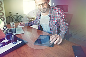 Man with digital tablet, laptop and pen at table