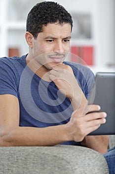 Man with digital tablet on sofa