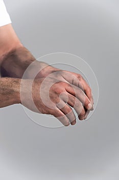 Man with dirty hands on grey background.