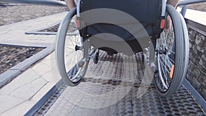 A man with disabilities moves along the street in a wheelchair