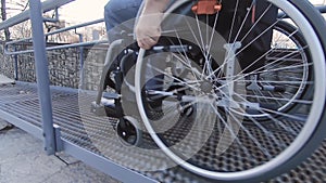 A man with disabilities moves along the street in a wheelchair