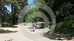 A man with a disability cerebral palsy travels. Behind the backpack, looking at the map and goes down the road. Normal life