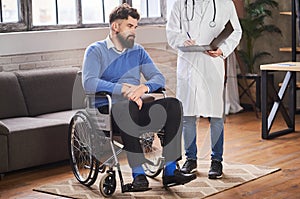 Man with disability listening to a doctor in his home