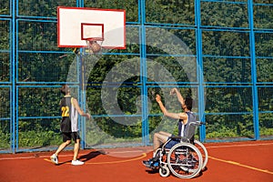 Man with disability playing basketball with friend at sports court.