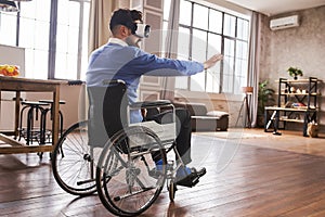 Man with disability sitting in a wheelchair and using a VR headset