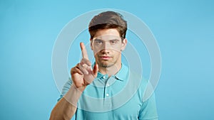 Man disapproving with no finger sign make negation gesture. Denying, Rejecting, Disagree, Portrait of guy on blue