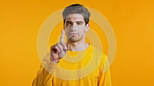 Man disapproving with no finger sign make negation gesture. Denying, Rejecting, Disagree, Portrait of guy on yellow