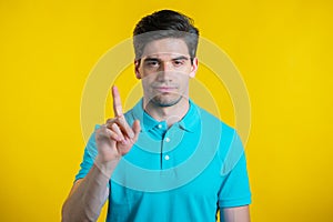 Man disapproving with no sign make negation finger gesture. Denying, Rejecting, Disagree, Portrait of guy on yellow