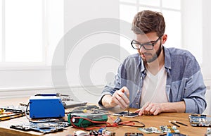 Man disassembling smartphone in repair shop