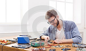 Man disassembling smartphone in repair shop