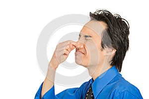Man disgust on his face pinches his nose, something stinks bad smell photo