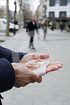 Man disinfecting his hands with a wet wipe