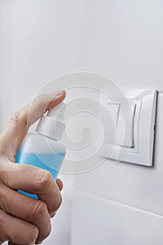 Man disinfecting the light switch