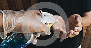 Man disinfecting a person`s hands