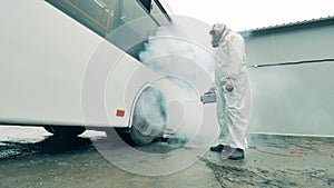 Man disinfects a bus with a sprayer during coronavirus pandemic. Disinfect, disinfection concept.