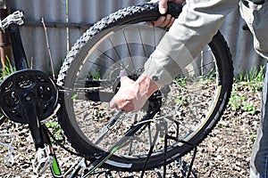 A man dismantles the rear wheel of a bicycle